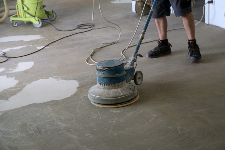 Subfloor being cleaned and leveled before flooring installation.