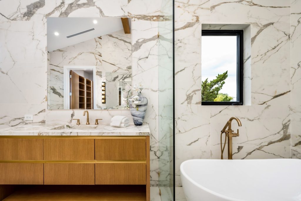 A contemporary bathroom featuring PVC marble sheets on the vanity and walls.